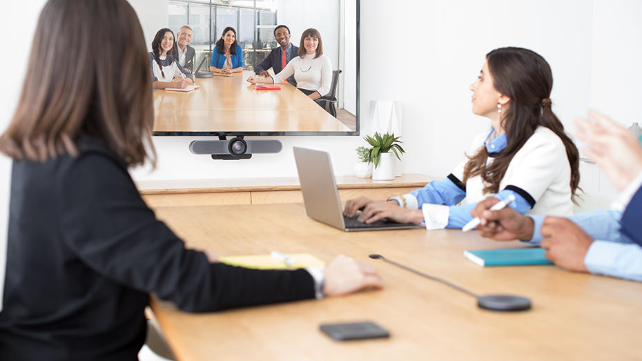 People at conference table video conferencing